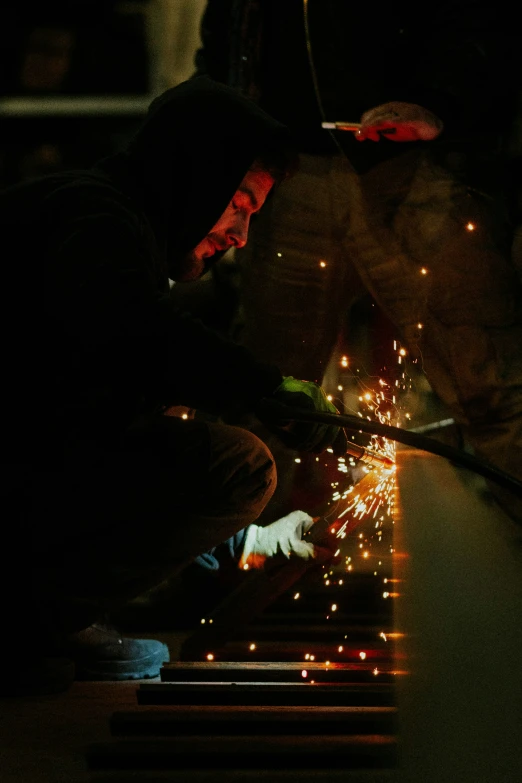 a man sitting down next to a lit firework