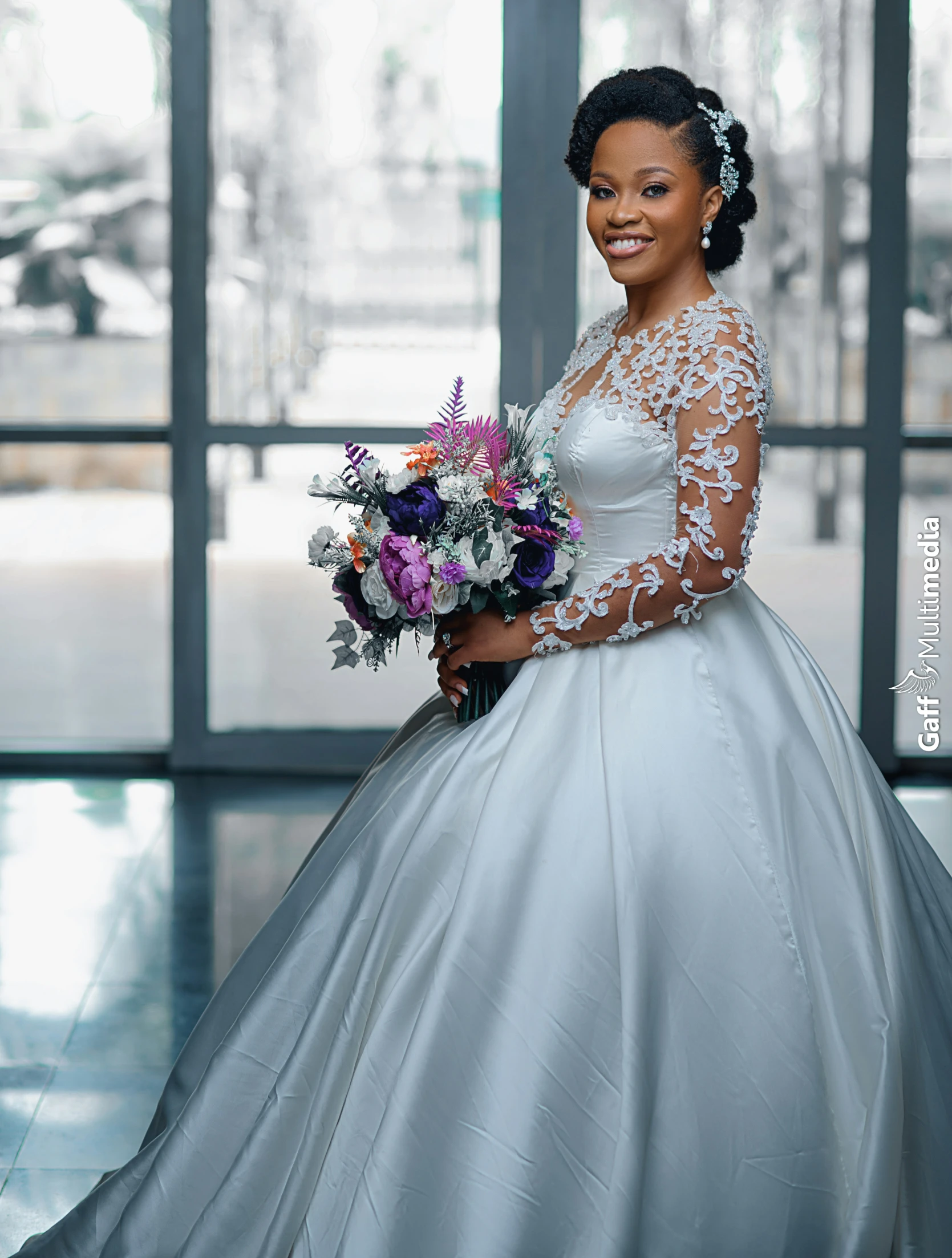 a bride wearing a long sleeved white wedding gown with sheer top