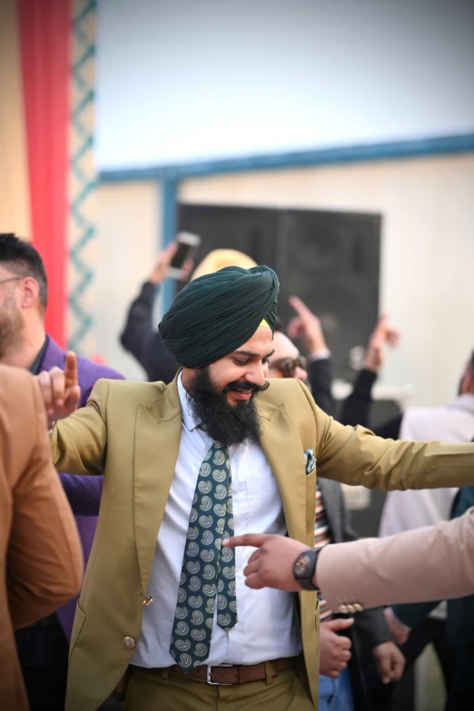 a man with a green turban is dancing