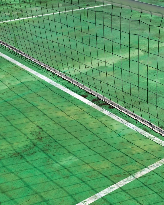 there is a green tennis court that has net on it