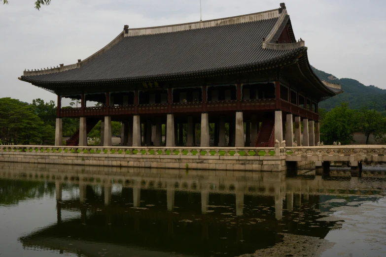 there is an oriental building on the bank of the river