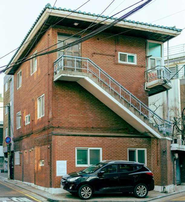 a small car parked next to an apartment building