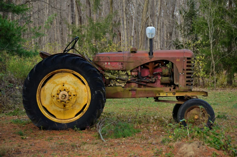 an old rusted out tractor sitting in the woods