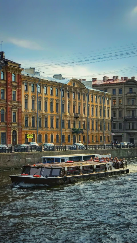 several boats going on the water with old buildings around