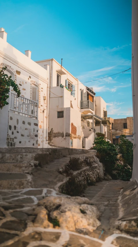 a view looking up at a row of white houses and a street