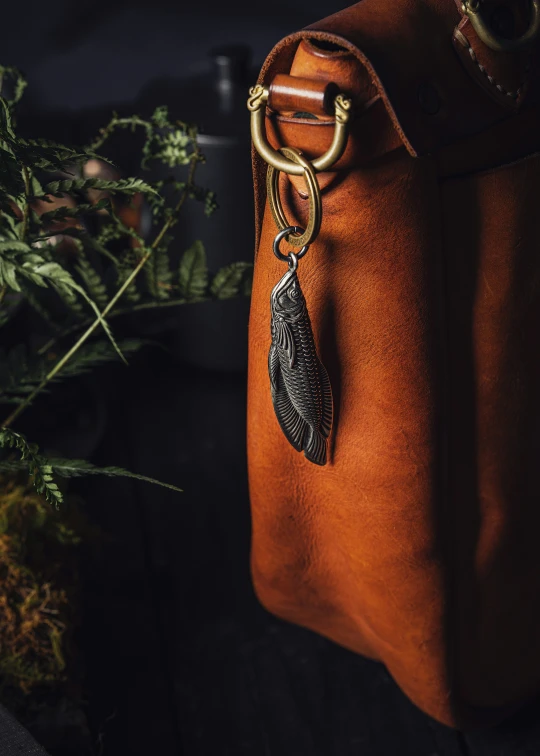 the brown leather backpack has an owl design on it