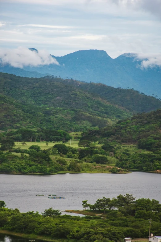 the boat is floating in the water with mountains in the background