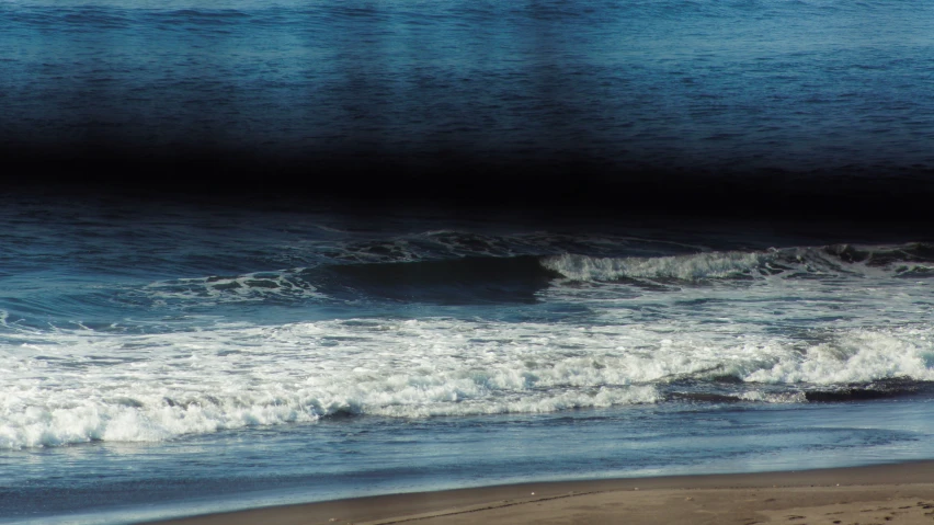 the waves of the ocean are rushing on the beach