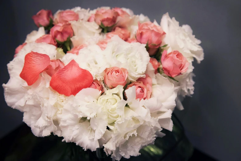 a white and red arrangement of flowers in a vase