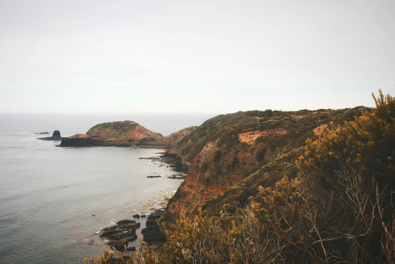 the ocean is calm, but you can see many rocks on it