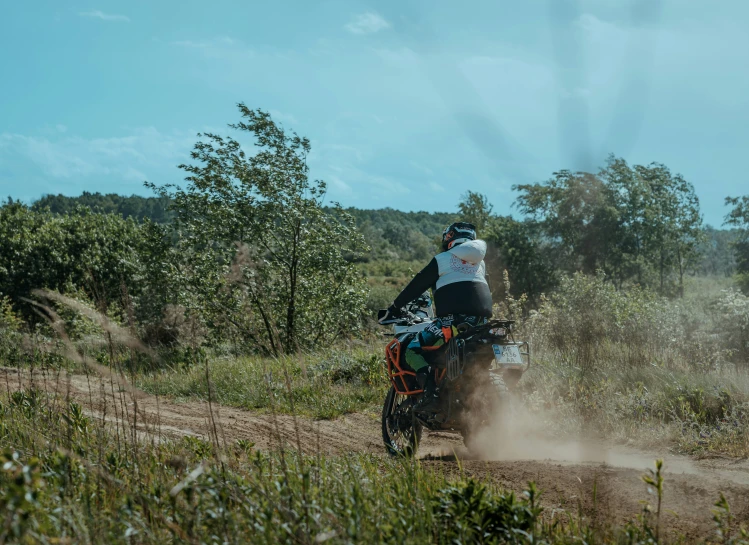 a man on a motorcycle driving through the woods