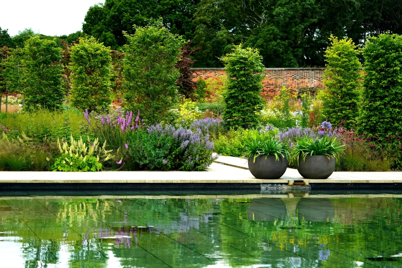 a large garden with large planters sitting next to water