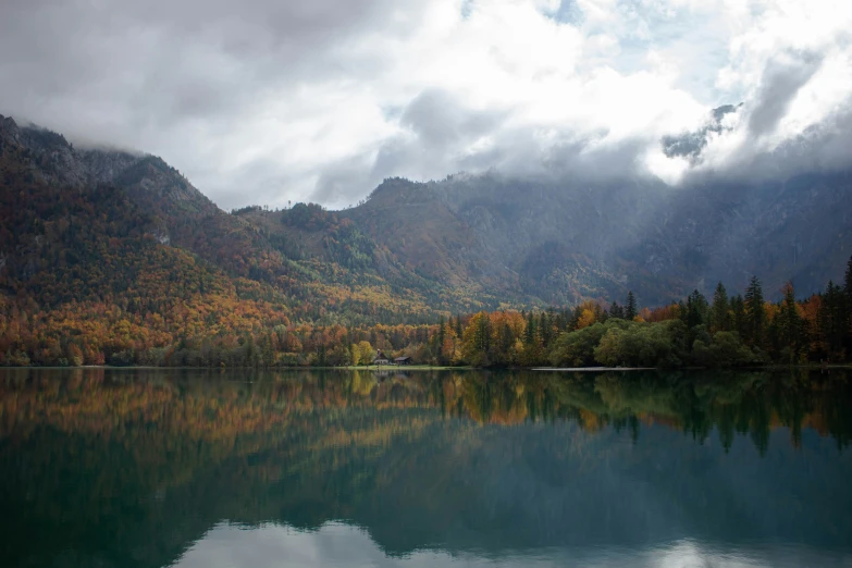 mountains reflected in a still lake surrounded by trees