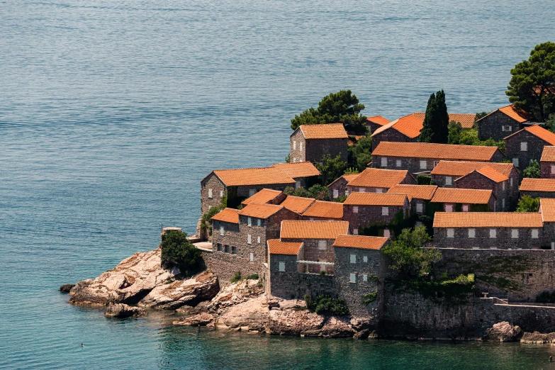 the view from above of a small house on the water with red roofs