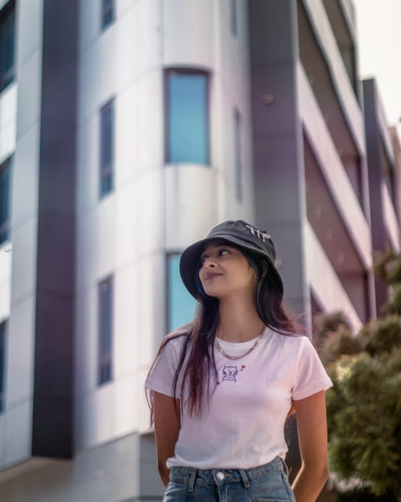 a woman is standing by a big building