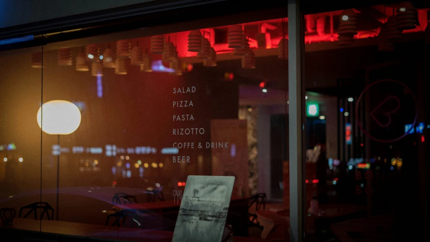 red and white lights reflected in the window of a store