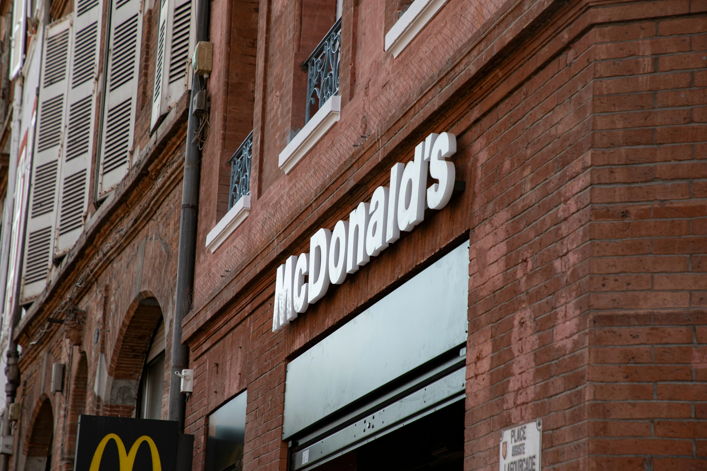 a mcdonalds sign on a brick wall near a mcdonalds