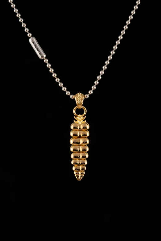 a gold beaded necklace on a black background