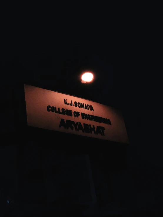 an orange sign sitting at the entrance to a dark room