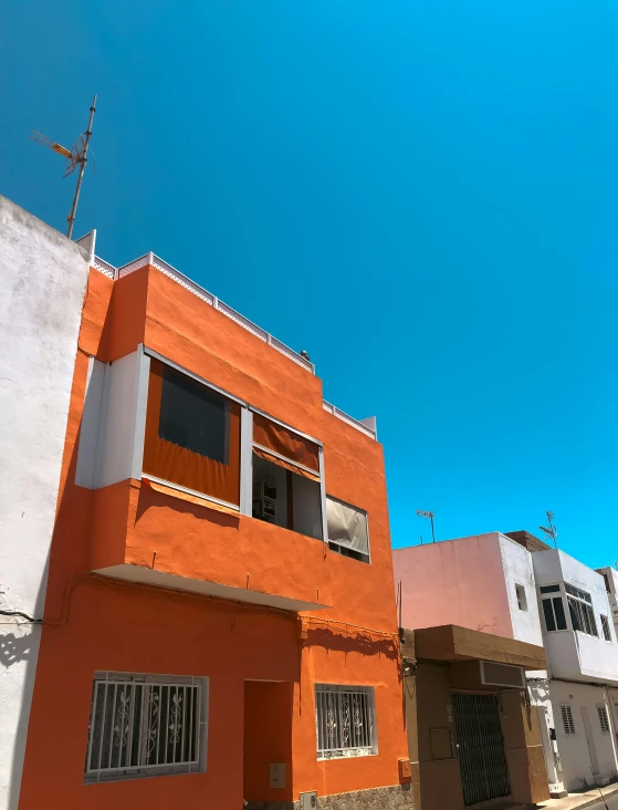 a tall orange building sitting on the side of a street