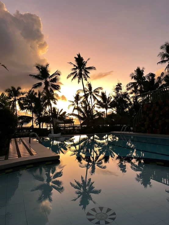 a pool with water at dusk next to the beach