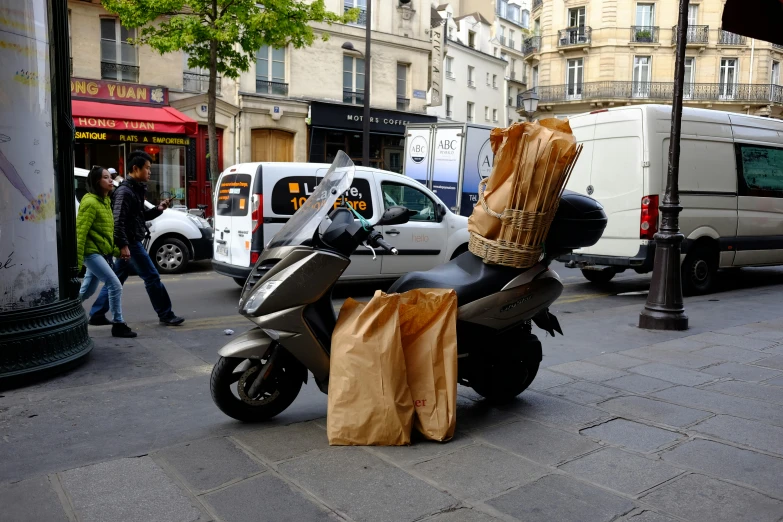 a scooter is parked on the street near people walking