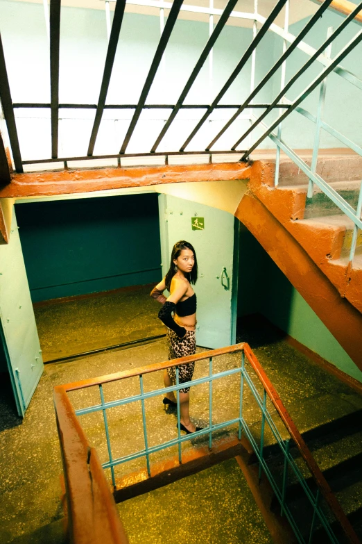 a girl in a hallway standing at a railing