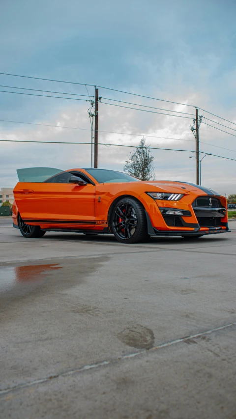 an orange sports car parked on the pavement