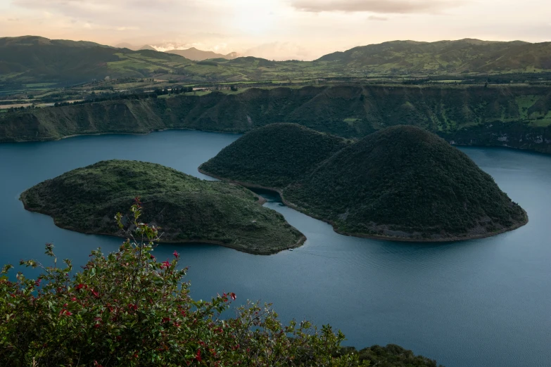 a lake surrounded by mountains and trees next to a forest