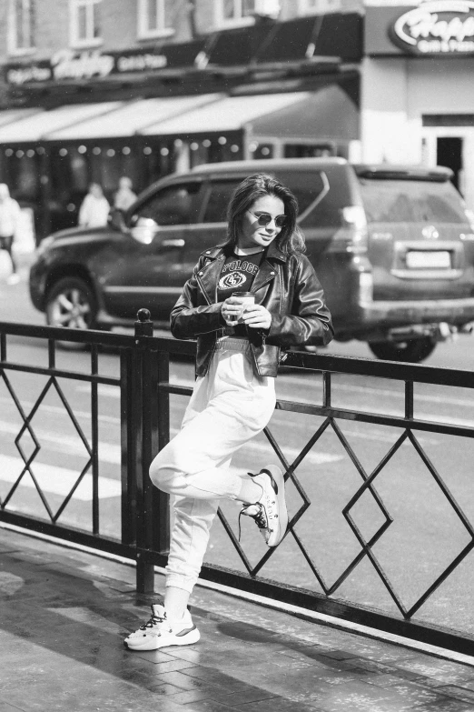 a woman with sunglasses and an outfit leaning on a railing