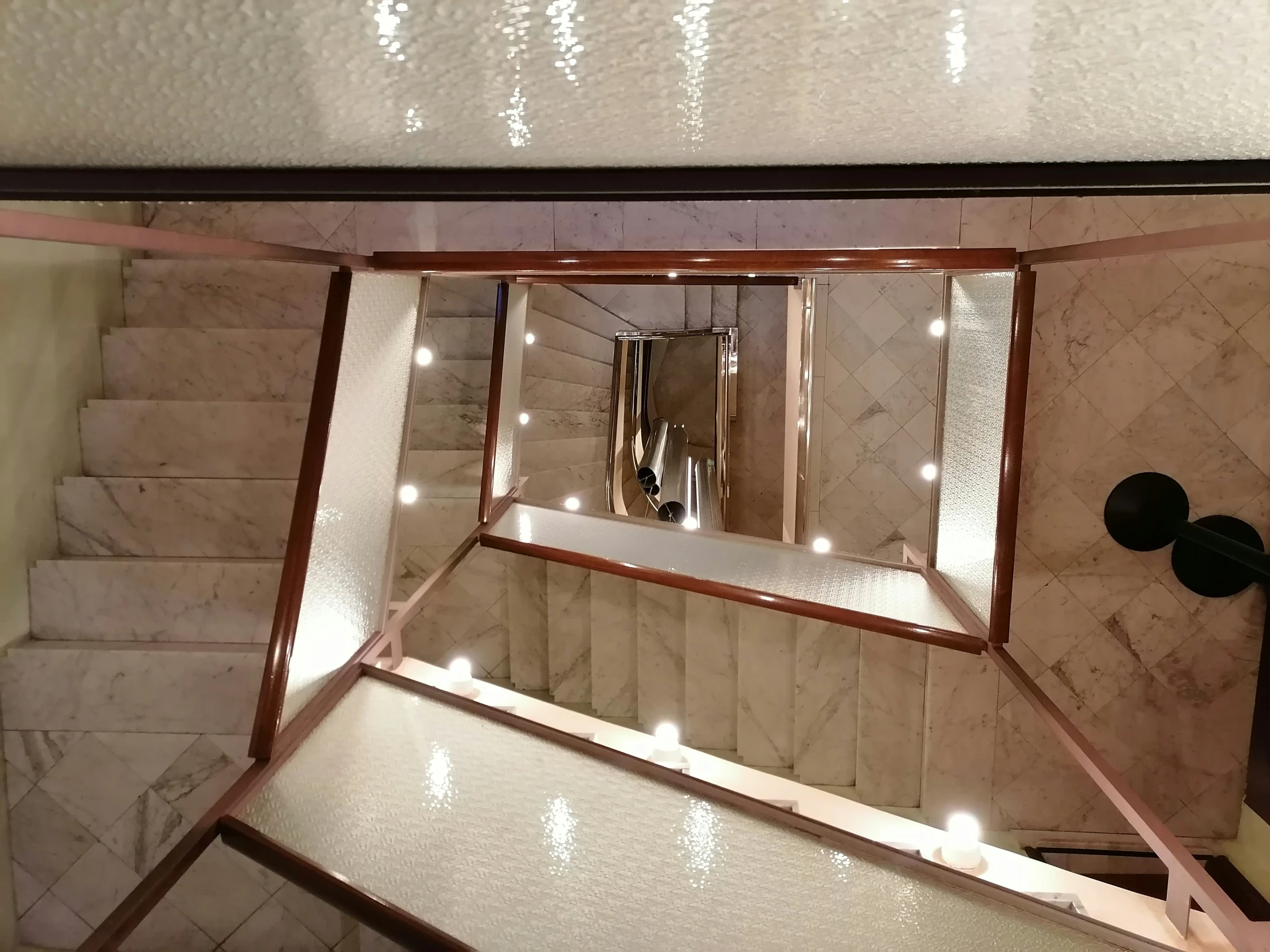 a white marble wall with mirror and lights around it