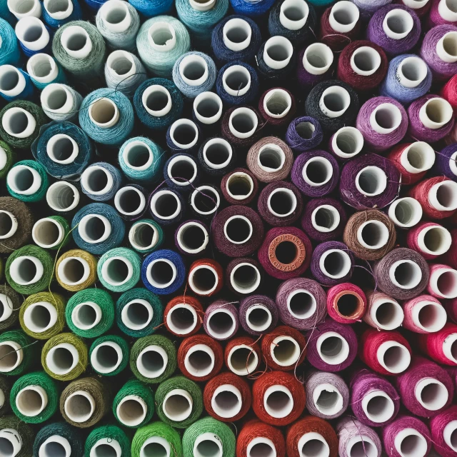 several spools of thread are stacked in rows