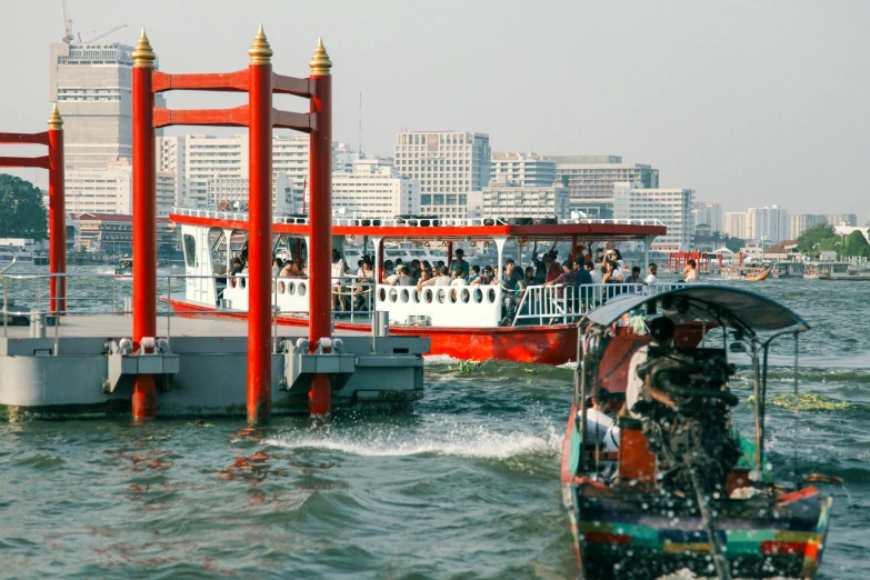 several people on a boat pass a floating structure