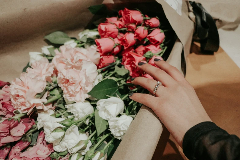 a person's hands putting a ring into some flowers