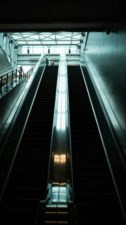 an escalator going through a building with lots of windows