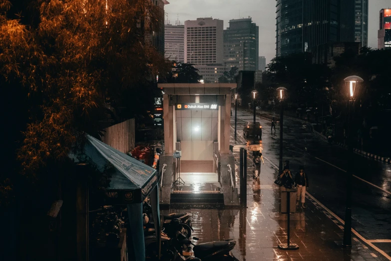 a bus stop with people on it as it is raining