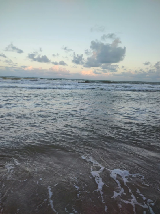 a lone beach on a hazy day with a surfboard