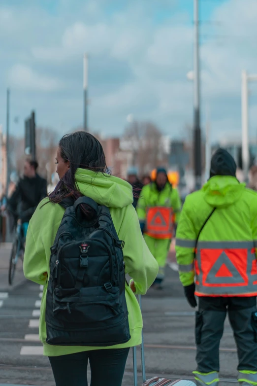 two people walk in front of people riding bikes