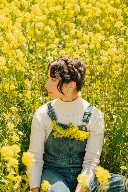 a  wearing overalls in a field full of yellow flowers