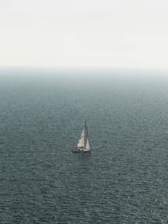 a boat is shown sailing on a misty day