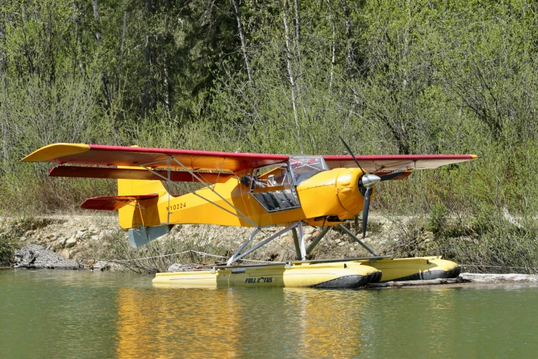 a yellow seaplane is floating in some water