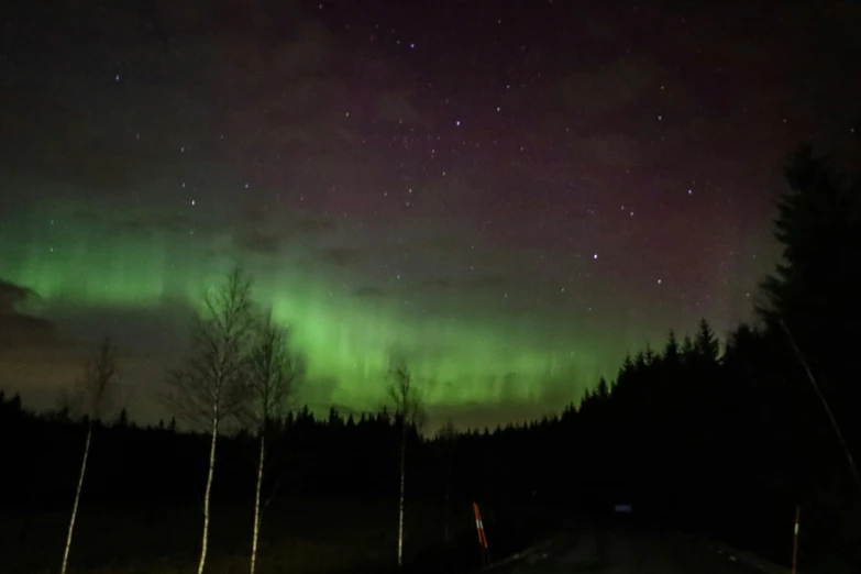 a road and a green and black aurora northern lights