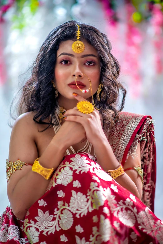 a woman in a red dress posing with her hands clasped