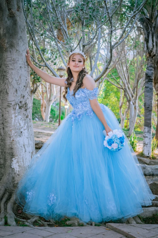 a beautiful little girl wearing a long dress in blue