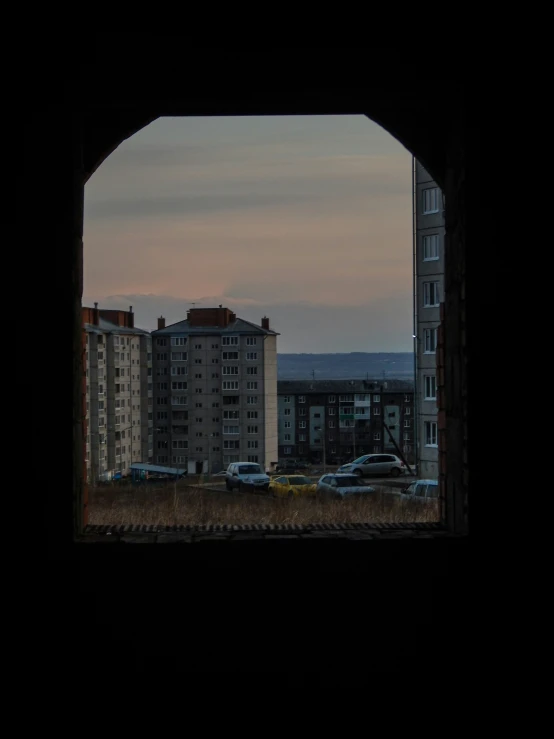 a view out an arch onto some buildings in the distance