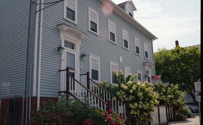 grey old fashioned home with white windows and front porch