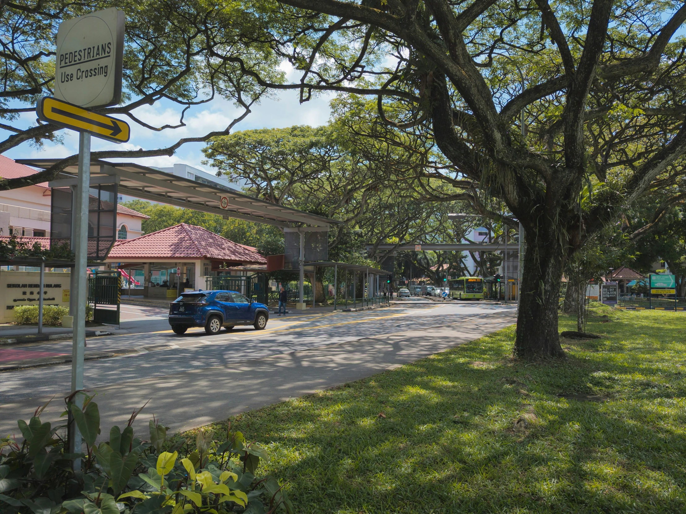 a small blue car driving down a street