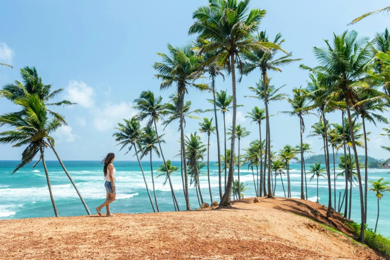 there is a woman that is walking near the ocean