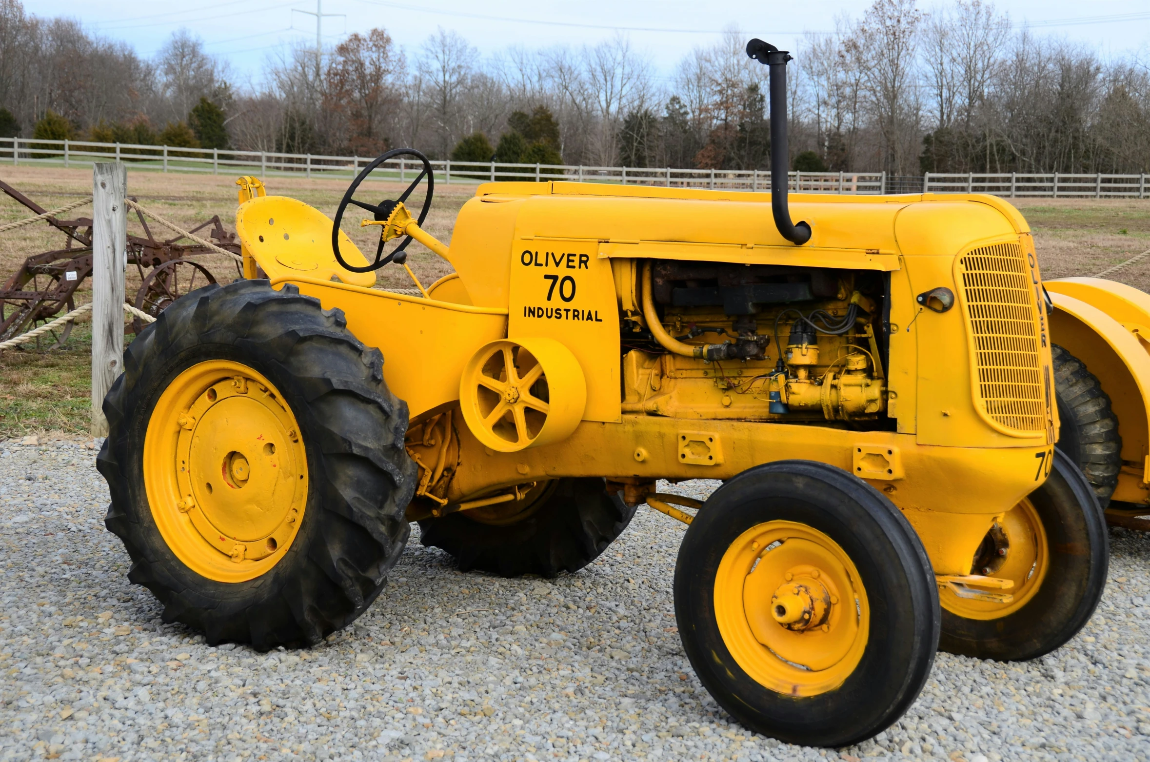 a yellow and black tractor parked on gravel