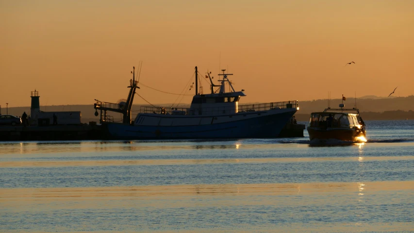 two boats sitting out on the water with one boat on the opposite side